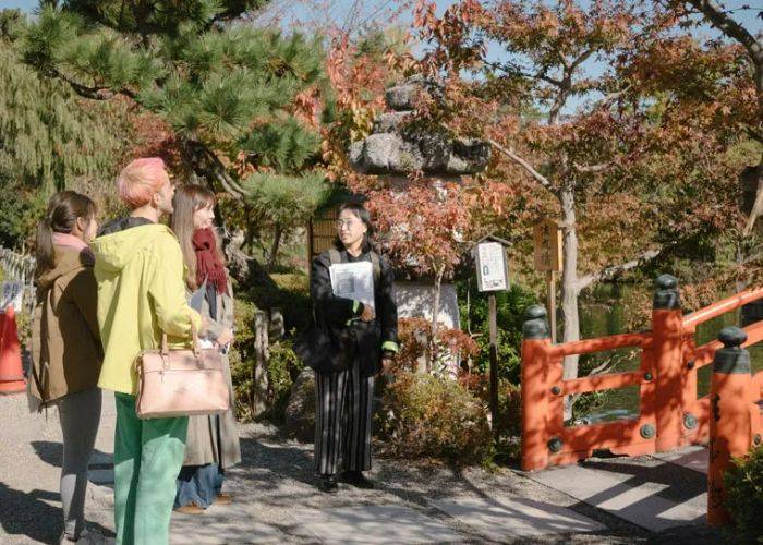 A group being taken around Kyoto by a tour guide.